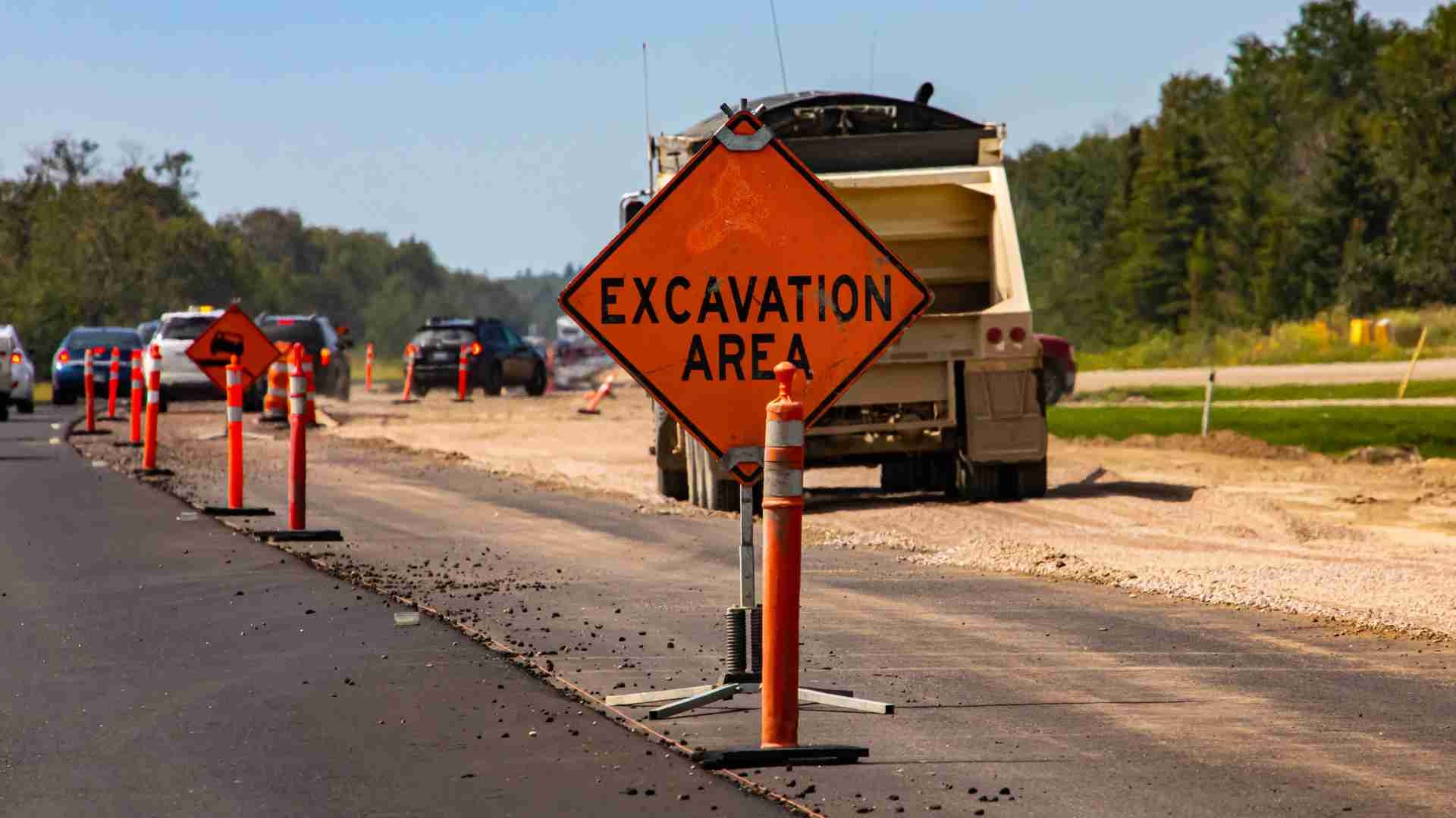 Yellow sign stating 'excavation area' on a work site in the middle of a highway